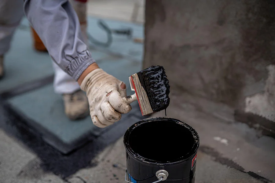 Basement waterproofing contractor applying foundation sealant in Amarillo